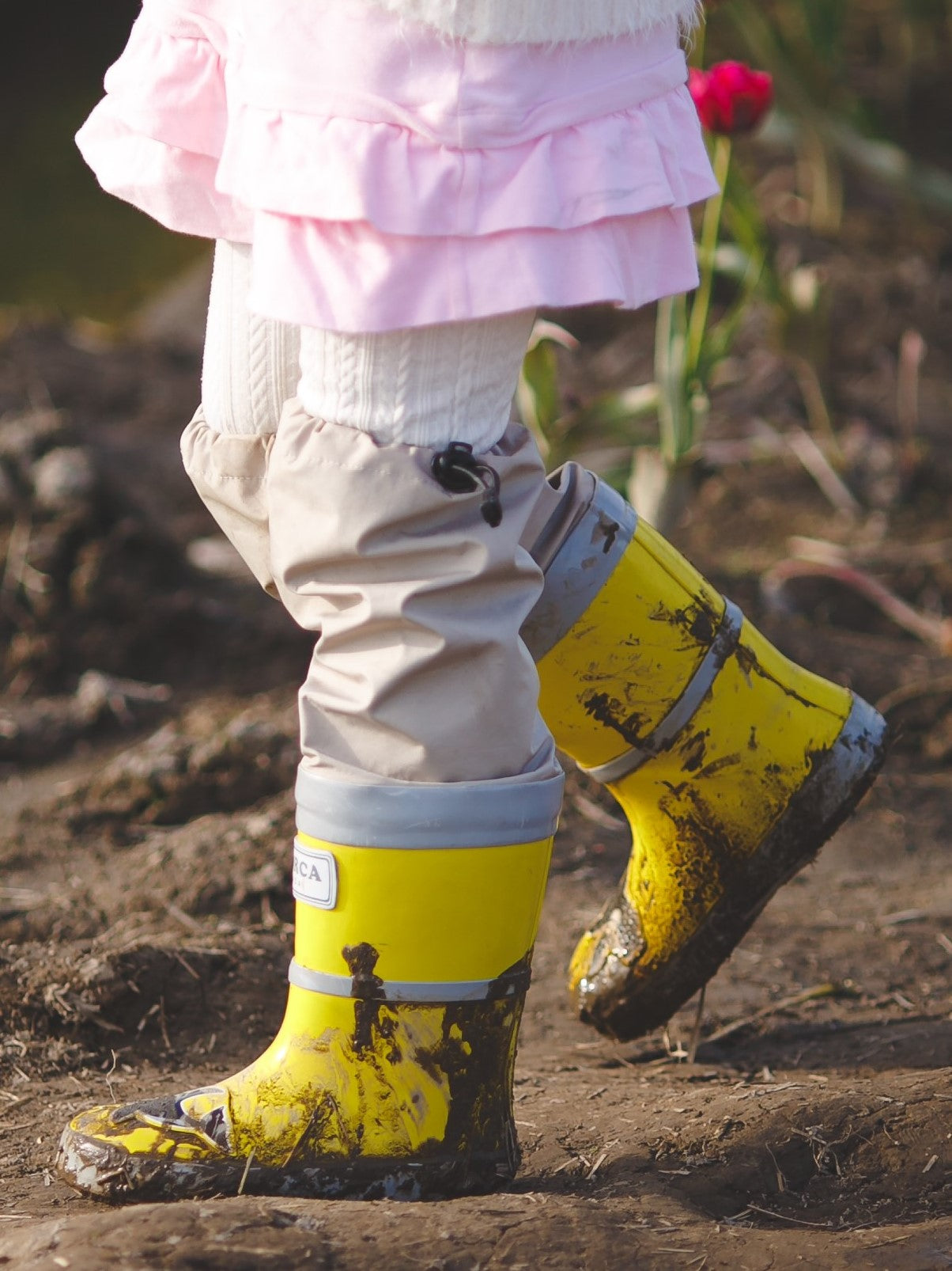 Child wearing yellow above-knee rain waders – side view