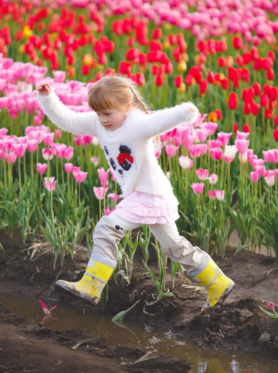 Child splashing in yellow rain boots with above-knee waders by KidORCA