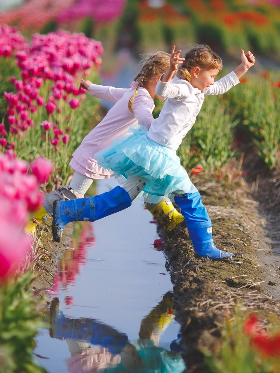 Child wearing blue above-knee rain waders – side view