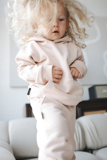 Child wearing pale rose french terry hoodie – side view with hood
