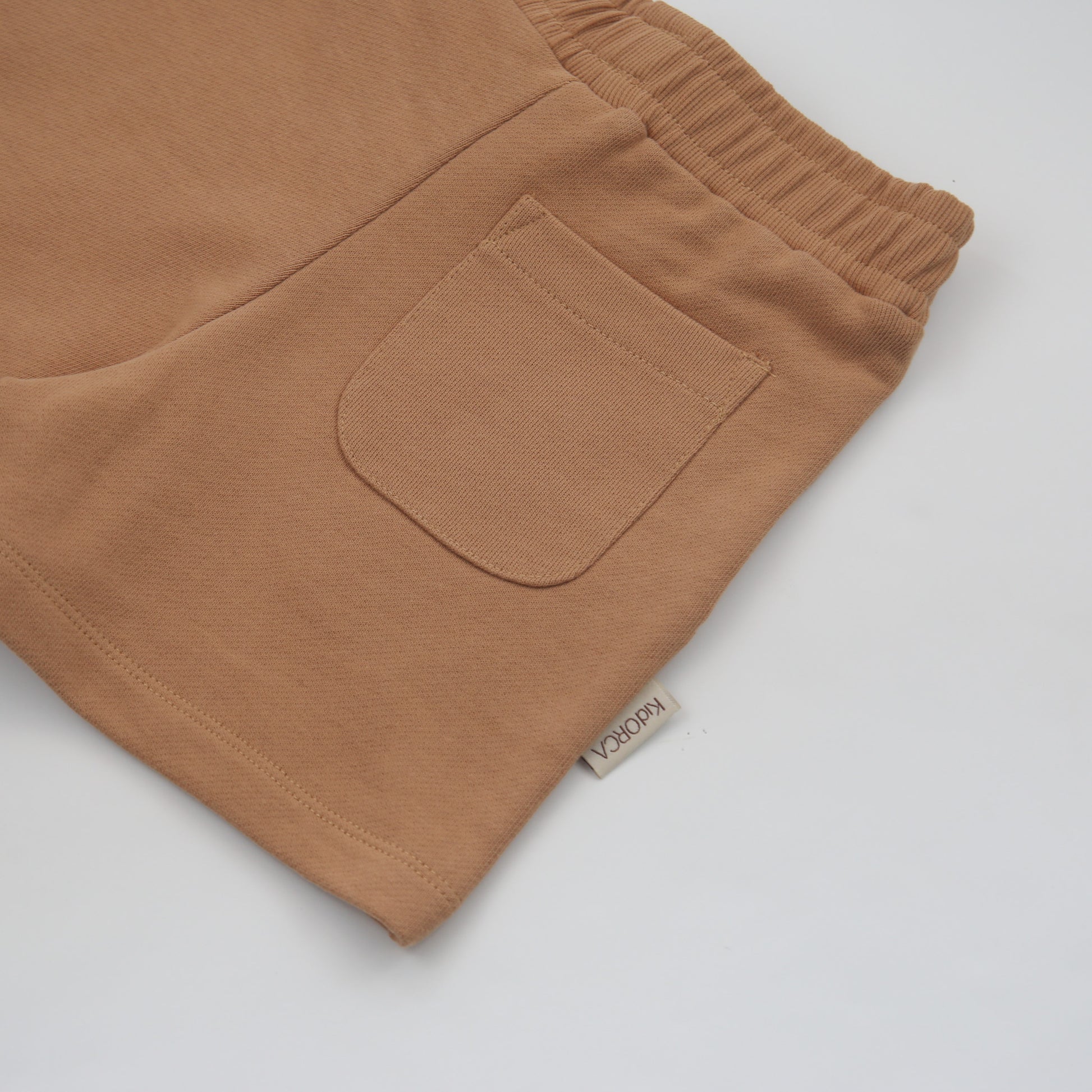Organic french terry kids shorts in sandstone beige – back view
