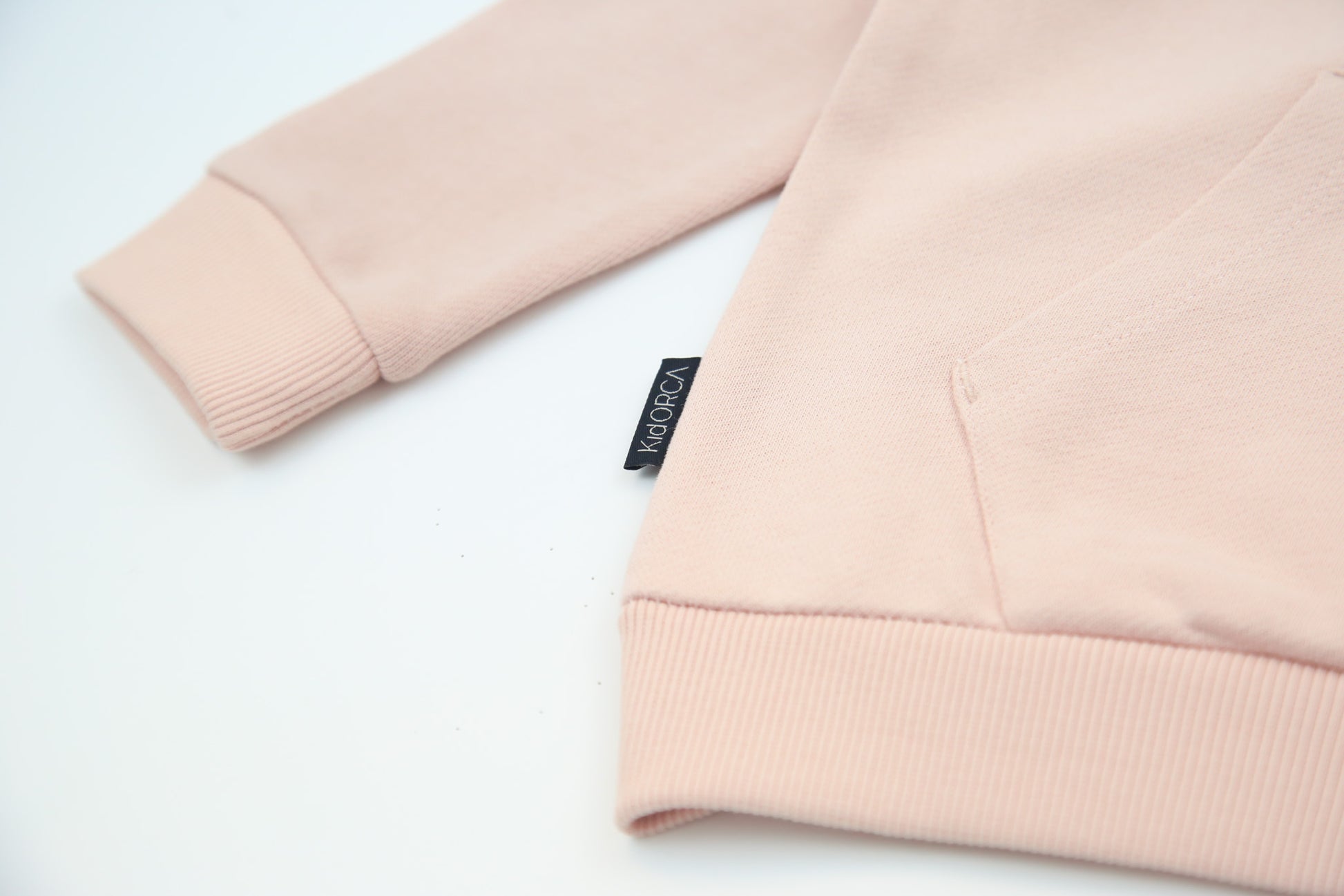 Kangaroo pocket and rib cuff detail on pale rose french terry kids hoodie