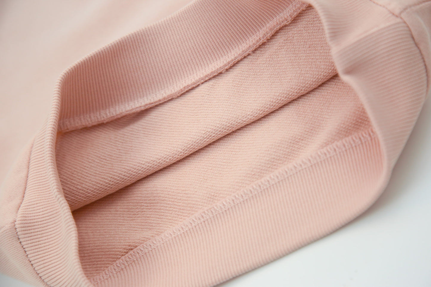 Close-up of soft organic french terry fabric texture – pale rose hoodie