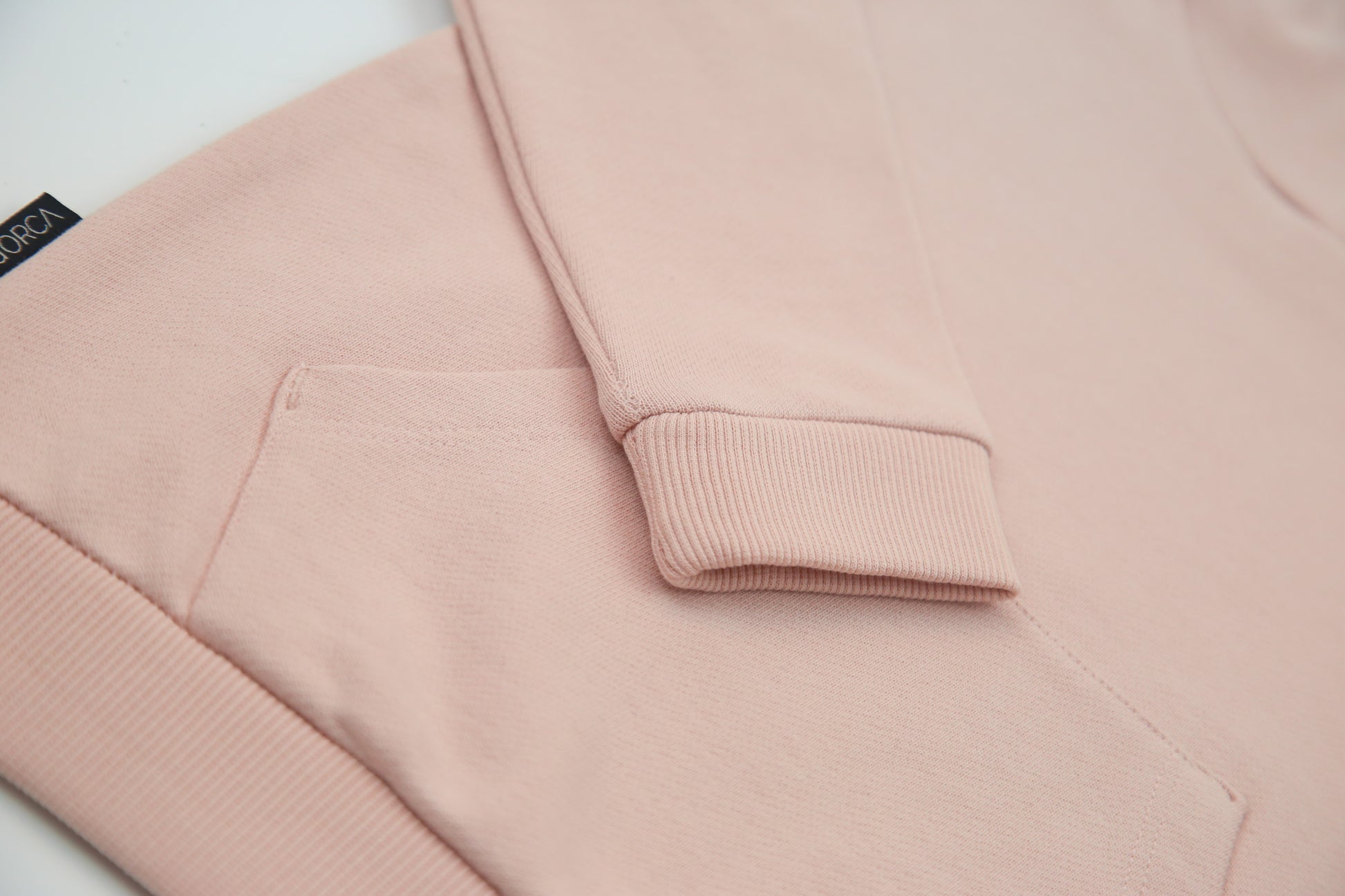Kangaroo pocket and rib cuff detail on pale rose french terry kids hoodie