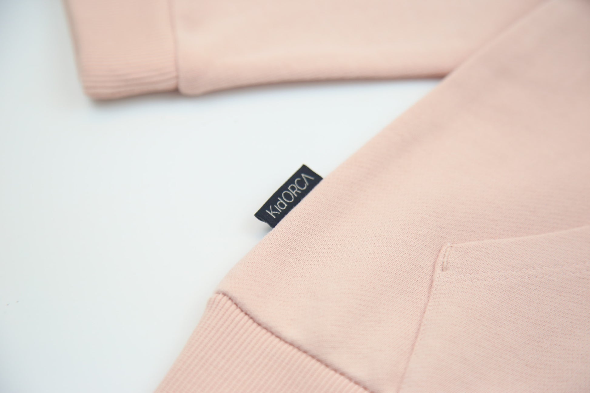 Kangaroo pocket and rib cuff detail on pale rose french terry kids hoodie