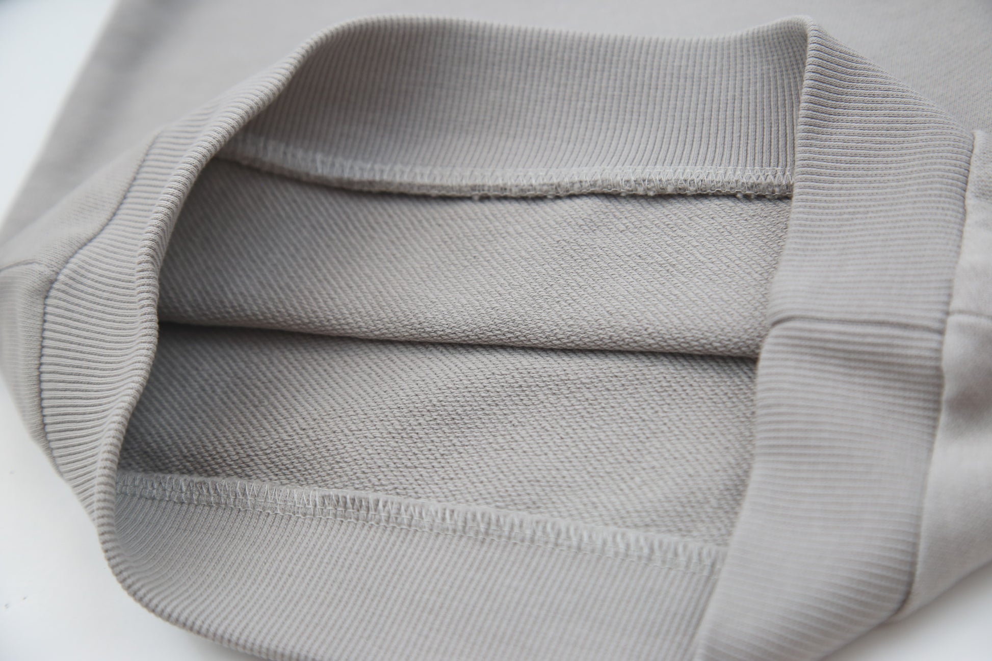 Close-up of soft organic french terry fabric texture – pebble grey kids hoodie