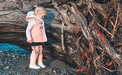 Child splashing in coral rain boots with above-knee waders by KidORCA